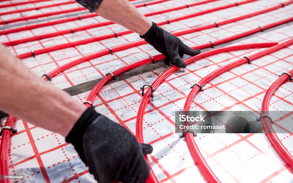 Pipefitter install system of underfloor heating system at home.